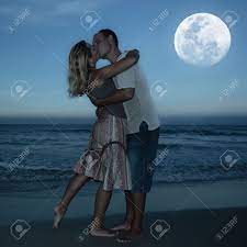 A couple looks out over the evening sky after sunset at moonlight beach in encinitas, california november 17, 2008. Young Couple Kissing At The Beach Under Moonlight Stock Photo Picture And Royalty Free Image Image 6440590