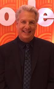 What is the host of iron chef america, known to bite into at the beginning of his show? Marc Summers Wikipedia