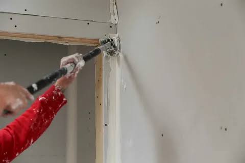 Interior room with drywall panels installed on the walls and ceiling