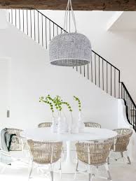 Contemporary white dining room with woven dining chairs and blue accents. Modern Minimal White Dining Room Design With Wicker Chairs And Saarinen Table On Thou Swell Saarine Beach Dining Room Living Room Table Sets White Dining Room