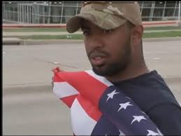 'Our Community Is Not Scared': Man Holds American Flag Outside Site of  Garland Shooting