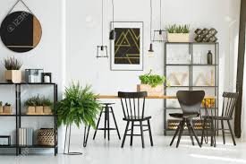 Showcasing a glossy round shade, the country industrial disperses a warm and powerful downlight perfect for task lighting purposes. Black And White Dining Room Interior With Industrial Lamps Above Wooden Table And Fern Stock Photo Picture And Royalty Free Image Image 97989902
