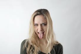 Represents a person sticking his or her tongue out with a little bit of attitude. Woman Sticking Her Tongue Out Free Stock Photo