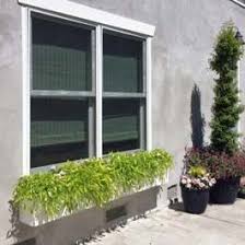 Decorative window box brackets help provide the look of traditional wooden window boxes and are a great way to enhance the curb appeal of your window box. Grass Window Box On Large Concrete Patio Unique Gardening Window Box White Planter Boxes Winter Window Boxes