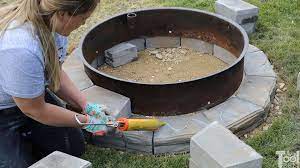 I found it a little difficult to glue the fire pit bricks with the construction adhesive. Diy Backyard Fire Pit Her Tool Belt
