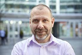 Gündelik Kıyafetli Sakallı Düşünceli Adam Gülümsüyor Ve Bir şeyler Hayal  Ediyor Fotoğraf Arka plan Ve Ücretsiz İndirmek İçin Resim