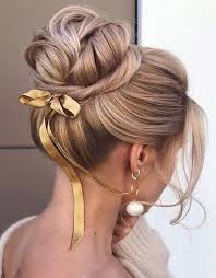 A messy bun and a butterfly accessory. Excellent Updo Bun Hairstyles Images In 2019 Stylezco