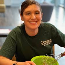 At last week's Cooking with Keri session, we learned how to bake chocolate  cupcakes — a delicious, sweet treat for all to enjoy! ID: A small group  sits at a table with