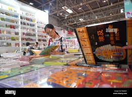 In this Wednesday, Aug. 22, 2018, photo, Ellen Watterson reenacts an 1830s  farm worker milking a cow named May in a barn at Old Sturbridge Village, in  Sturbridge, Mass. With a $75,000
