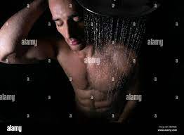 Sexy portrait of muscular naked man with pecs and sixpack abs under  rainfall shower with eyes closed Stock Photo - Alamy