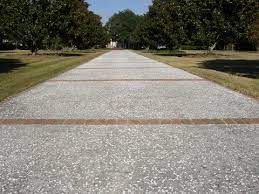 Water is the main culprit for damage to concrete driveways because it penetrates and expands. Oyster Shell Concrete Driveway With Brick Paver Apron Borders And Bands Driveway Landscaping Driveway Design Concrete Driveways