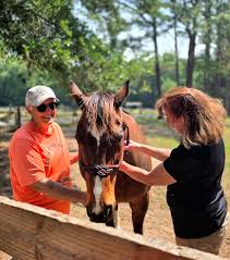 Retirement - Ann holds her handsome friend Champagne for his stick | Facebook