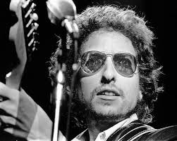 Bob Dylan cool pose wearing sunglasses playing guitar