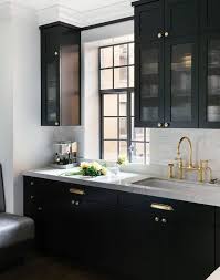 Black Kitchen Features Glass Reeded Upper Cabinets And Black Lower Cabinets Adorned With Polished Kitchen Cabinet Design Black Kitchen Cabinets Black Kitchens
