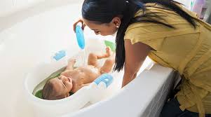 It's easier if someone else holds your baby while you get in and out of the bath. Baby S First Bath How To Bathe A Newborn