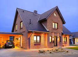 Beleuchtetes Einfamilienhaus Mit Bullauge Und Kapitansgiebel Bei Nacht Massivhaus Einfamilienhaus Haustypen