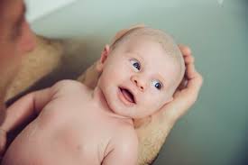 Taking a bath together can support the. Father And Baby Taking A Bath Together Stockphoto