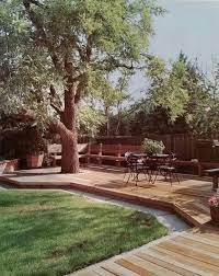 Often, the graceful solution will be to build a deck around the tree's trunk. Like The Low Deck Built Around Tree And Also The Color Of The Decking Patio Trees Backyard Patio Backyard