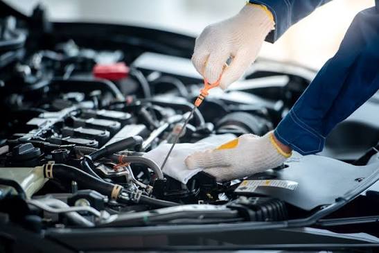 Mechanic checking engine oil