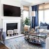 A neutral foundation of warm beige walls and white sofas allows pops of china blue to make a statement in this living room. 1