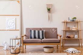 The peculiar shape of the high armrests and back characterize this living room set. Interior Design Of Living Room With Stylish Brown Wooden Sofa Stock Photo Picture And Royalty Free Image Image 154408589