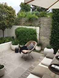 Reduced Color Scheme With Mix Of Material Low Stone Wall In Front Of Wooden Screen And Patio Garden Design Small Backyard Landscaping Small Backyard Gardens