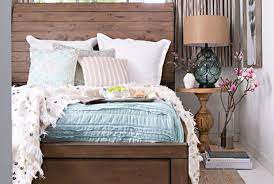 She added small traces of blue in the draperies, headboard, and euros to tie the space together. Blue Brown Bedroom Ideas Living Spaces