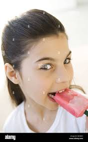 Portrait of Girl eating popsicle in garden Photo Stock