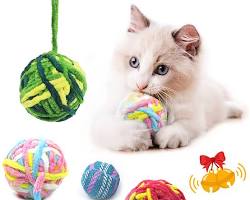 cat playing with a variety of yarn toysの画像