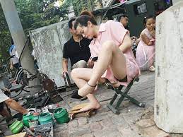 抓拍街头修鞋子的少妇，抬腿的时候走光了_中国街拍-真实街拍第一站