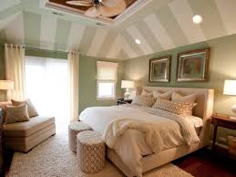 The vaulted ceiling adds height to the small bedroom, helping it to feel larger (image credit: Master Bedroom With Green And White Striped Vaulted Ceiling Hgtv