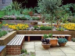 Stutzmauer Im Garten Bunte Blumen Sitzbank Backstein Blumentoepfe Zeitgenossische Gartengestaltung Kleine Hinterhofgarten Abschussiger Garten