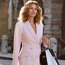 Black dress, flounce hem, patterned black hose, carrying shopping bags. Celebrating The Pretty Woman Julia Roberts At 53 Top 7 Movies