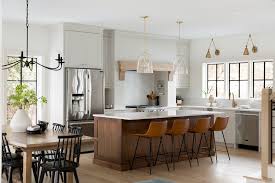 At the center is the kitchen island with an arctic white quartz countertop and black metal faucet in a contemporary silhouette. Modern Traditional Kitchen Remodel Painted And Walnut Stained Cabinetry Modern Farmhouse Kitchens Kitchen Remodel Custom Kitchen Island