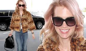 January Jones jets out of LAX in animal print jacket and funky flared jeans 