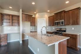 Something about grey which works just perfectly for kitchens. Warm Rich Medium Brown Cabinets Paired With Small Details Of Grey And Modern Subway Tile Make T Brown Kitchen Cabinets Brown Kitchens Kitchen Countertop Trends