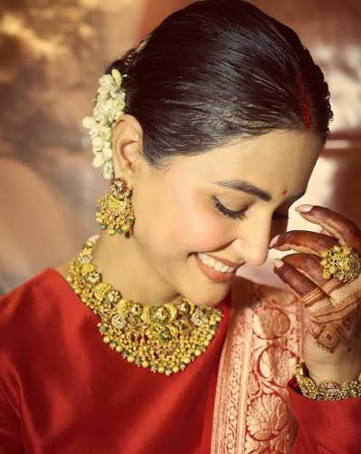 Hina Khan shared photos on Instagram celebrating her first Karwa Chauth after marrying Rocky Jaiswal in 2025. She looked stunning in a red suit paired with a Banarasi dupatta, heavy gold jewelry,