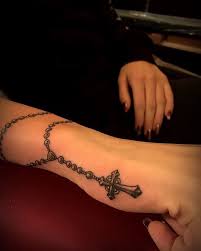 A common design is one with folded hands or praying hands holding the rosary with the beads wrapped around the hands or falling between the fingers. 10 Holy Rosary Tattoos Tattoodo