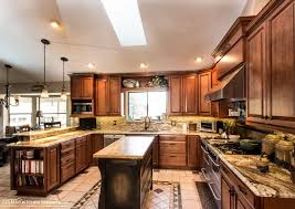 The dark, moody tile walls, sleek backsplash, and stainless steel appliances assert an undeniably glam aesthetic while the wood and brass tones ground the space and give it that classic classic califorina warmth. Zelmar Kitchen Designs More Orlando Cabinetry Design Remodeling