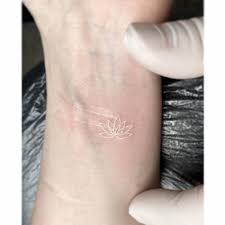 We design tattoo art to order, and we use the industry's highest quality of body jewelry. Fine Line Lotus Flower Tattoo In White Ink