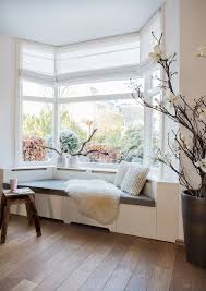 This large bedroom is divided into different spaces including the main bed with its fluffy silk sheets and headboard, the day bed and its simple brown color, and a bay window to the far end with a patterned window valance. Bay Window Seat Ideas How To Create A Cozy Space In Any Room