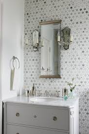 This elegant white bathroom features matching vanities, mirrors and wall sconces. Savvy Southern Style Tiled Vanity Walls