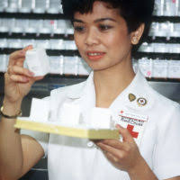 Bridget Corcoran, a Red Cross volunteer worker, weighs an infant at the  Fort Polk Hospital Well-Baby Clinic