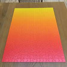 Each of the 1000 pieces is printed using a lenticular lens which gives the individual tiles the ability to shift between two different color states, depending on the angle of view. A Gradient Puzzle Mildlyinteresting