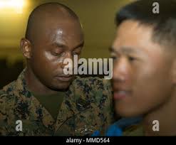 Navy Hospital Corpsman 2nd Class Rudy Harris, a New Zealand native,  attached to 3rd Marine Logistics Group, III Marine Expeditionary Force,  administers a flu shot to a Marine