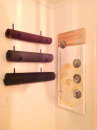 Part storage and part display, the shelf is designed to store a yoga mat and two yoga blocks. Home Gym Needed A Place To Store My Yoga Mats Plant Hook Painted Turned Upside Down Mounted On My Wall Little P Yoga Mat Storage Home Yoga Room Diy Yoga