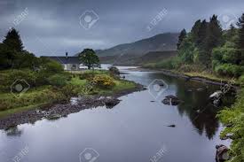 Maybe you would like to learn more about one of these? The Shallow Bluish Gray Reflecting Hope River Meanders Through A Green Landscape In Front Of Tall Mountains Shades Of Green And Yellow Accents By Broom Flowers Half Hidden House Stock Photo Picture