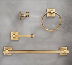 A white barn door on rails opens to an en suite bathroom boastin ga white curved bath vanity fixed beneath a round gold mirror. Pearson Bathroom Hardware Pottery Barn