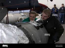 Aviation Structural Mechanic (Safety Equipment) 2nd class Jared Gray, left,  from Sacramento, Calif., and Aviation Structural Mechanic (Safety  Equipment) 1st class Caleb Mitts, from Orlando, Fla., load an aerial drop  tank on
