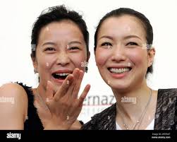 Actresses Su Yang, left, and Sammi Cheng from Hong Kong pose for  photographers after a press conference to present their latest movie  "Changhen Ge"(Everlasting Regret), directed by Stanley Kwan at the 62nd